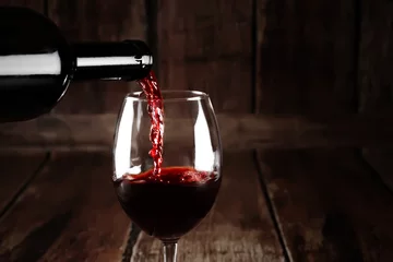 Poster Red wine pour from bottle © alexugalek