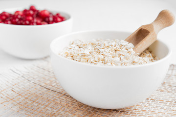 Rolled oats, porridge and cranberries for a healthy breakfast in a rustic style