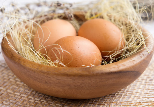Chicken eggs in wooden plate closeup in rustic style