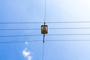 Electrical wires against the blue sky