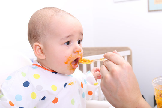 Mother feeding her baby solids