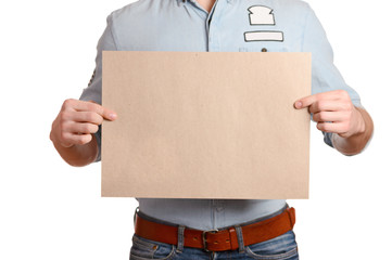 Stylish man in a light denim shirt and dark blue jeans is holding a blank sheet