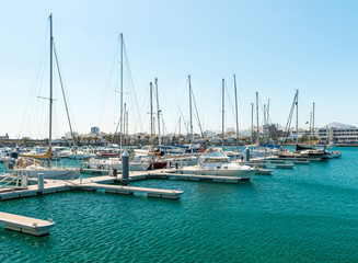 Fototapeta na wymiar Empty slots in harbor, some boats, Spain