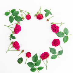 Round frame with red roses and leaves isolated on white background. Flat lay, top view