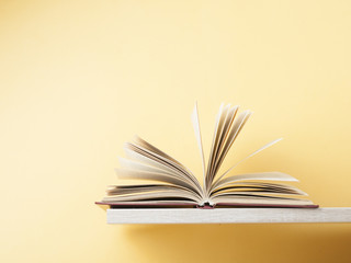 Open book on wooden shelf . Education background. Back to school. Copy space for text.