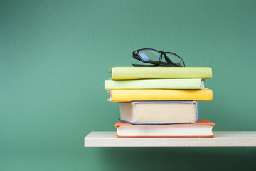 Stack of books on wooden shelf. Education background. Back to school. Copy space for text.