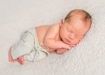 Baby in comfy pants, slightly frowning