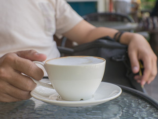 Fototapeta na wymiar Male hands holding a cup of coffee on table
