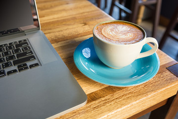 Working with laptop and coffee cup on wooden table