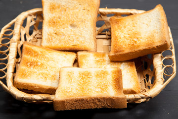 Toast the bread on a black wooden background