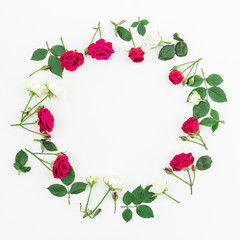 Round frame with red roses and leaves isolated on white background. Flat lay, top view