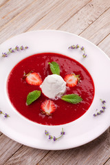 Strawberry soup with ice cream and mint. Pureed strawberries garnished with mint leaves topped with vanilla ice cream. Blended berries. Berry dessert