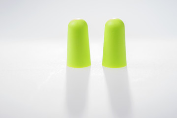 Two green ear plugs isolated on white background