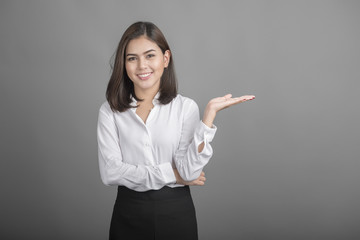 Beautiful Business Woman presenting something on grey background