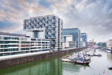 Obraz premium Modern business center on blue sky background in Cologne, Germany. Cologne Kranhaus - modern complex of buildings on the bank of Rhine with beautiful panoramic views in blue tones.