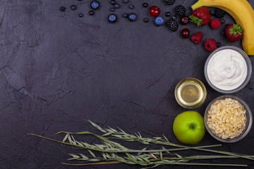 Bowls of Yogurt and Oat Flakes, Fresh Apples, Honey and Summer Berries. View from above, top studio shot of fruits. Flat lay setup made of healthy food, copy space, horizontal composition