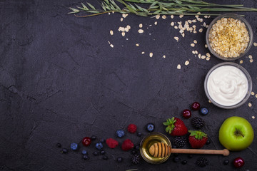 Bowls of Yogurt and Oat Flakes, Fresh Apples, Honey and Summer Berries. View from above, top studio shot of fruits. Flat lay setup made of healthy food, copy space, horizontal composition