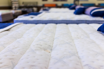 Closeup of many mattresses on display in store