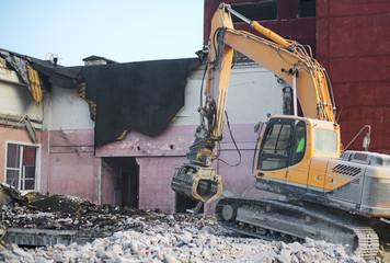 Hydraulic demolition crane dismantling school building.