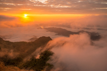 Fototapeta na wymiar The beautiful sunrise over landscape of the sea mist cover the highland mountains named Phu Chi Dao located in Chiang Rai province in northern region of Thailand.