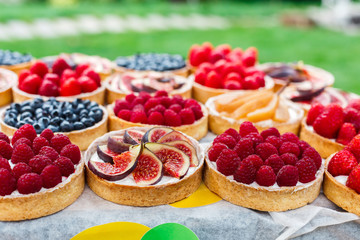 Fruit and berry tarts dessert tray assorted outdoors