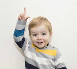 Adorable child pointing up on white background