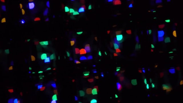 Abstract bokeh holiday background. Decoration of blinking garlands through defocused bars. Christmas and new year lights twinkling. Celebration spirit in merry flashing colorful bubbles in 4k clip.
