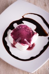 Top view on creamy dessert with berry sauce and chocolate topping