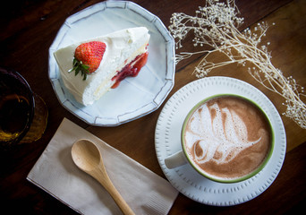 coffee cup and strawberry cake in coffee shop  with wood backgro