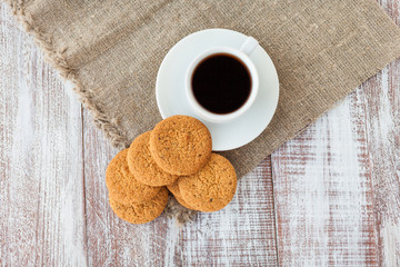 Cup of coffee, cookies, walnut and chocolate on the white wooden
