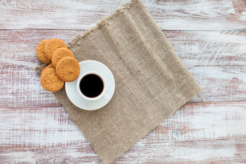 Cup of coffee, cookies, walnut and chocolate on the white wooden