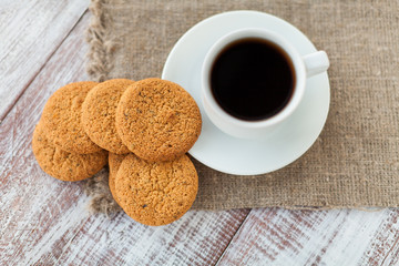 Cup of coffee, cookies, walnut and chocolate on the white wooden