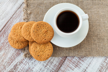 Cup of coffee, cookies, walnut and chocolate on the white wooden