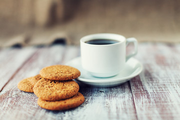 Cup of coffee, cookies, walnut and chocolate on the white wooden