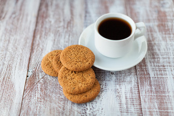 Cup of coffee, cookies, walnut and chocolate on the white wooden