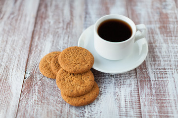 Cup of coffee, cookies, walnut and chocolate on the white wooden