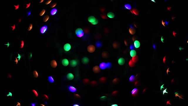 Abstract holiday background with fairy tale blinking lights. Christmas and new year twinkling decoration. Celebration spirit in merry flashing colorful specks on dark night backdrop in full HD clip.