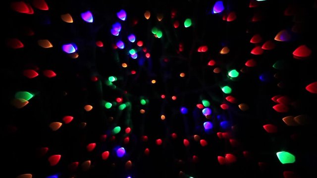 Abstract holiday background with fairy tale blinking lights. Christmas and new year twinkling decoration. Celebration spirit in merry flashing colorful specks on dark night backdrop in fancy HD clip.