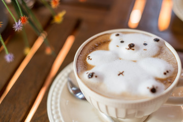 Latte coffee art with 3D bear milk foam in the white glass on wood background