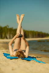 Woman in bikini sunbathing and relaxing on beach