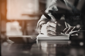 People writing on notebook and work with calculator and laptop o