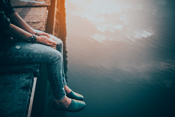 girl on a bridge on the sunset in sad and lonely concept