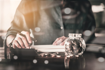 Close up of people hand work calculator and money,coins in finan