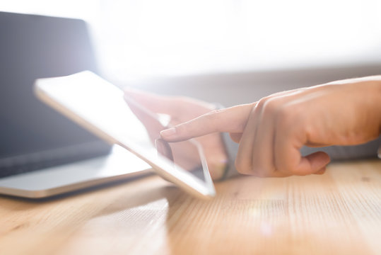 Hands using tablet screen at workspace