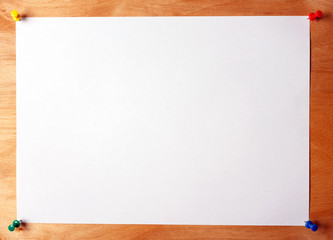 A sheet of paper attached to a wooden board with multicolored buttons