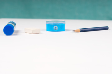 Pencil sharpener and elastic on the white paper.