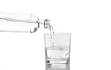 Pouring water in a glass on white background