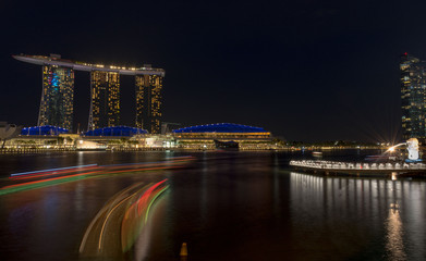 Fototapeta na wymiar night time cityscape of Singapore with light reflections in the water - built on reclaimed land