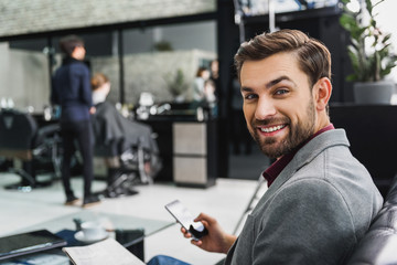 Cheerful man sitting in hairdressers