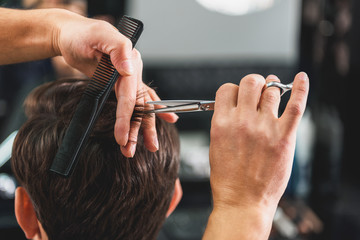 Skillful male barber doing haircut